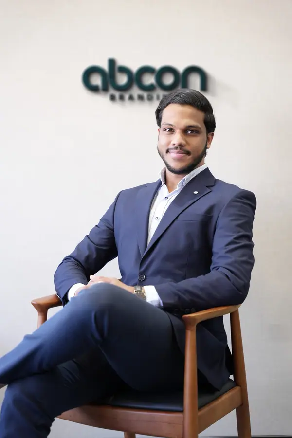Muhammed Shafad in a navy suit in front of the Abcon Branding wall